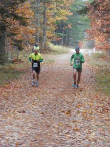 Left to Right: Local runner Ozzie Townsend, Jr, Perry, and Maine running icon Gary Allan, Cranberry Isles, racing through the beautiful Moosehorn National Wildlife Refuge in the 2016 WCCC Ghost Run.  Allan commented “This is what running used to be like. Thank You!”  (Sarah Mulcahy photo)