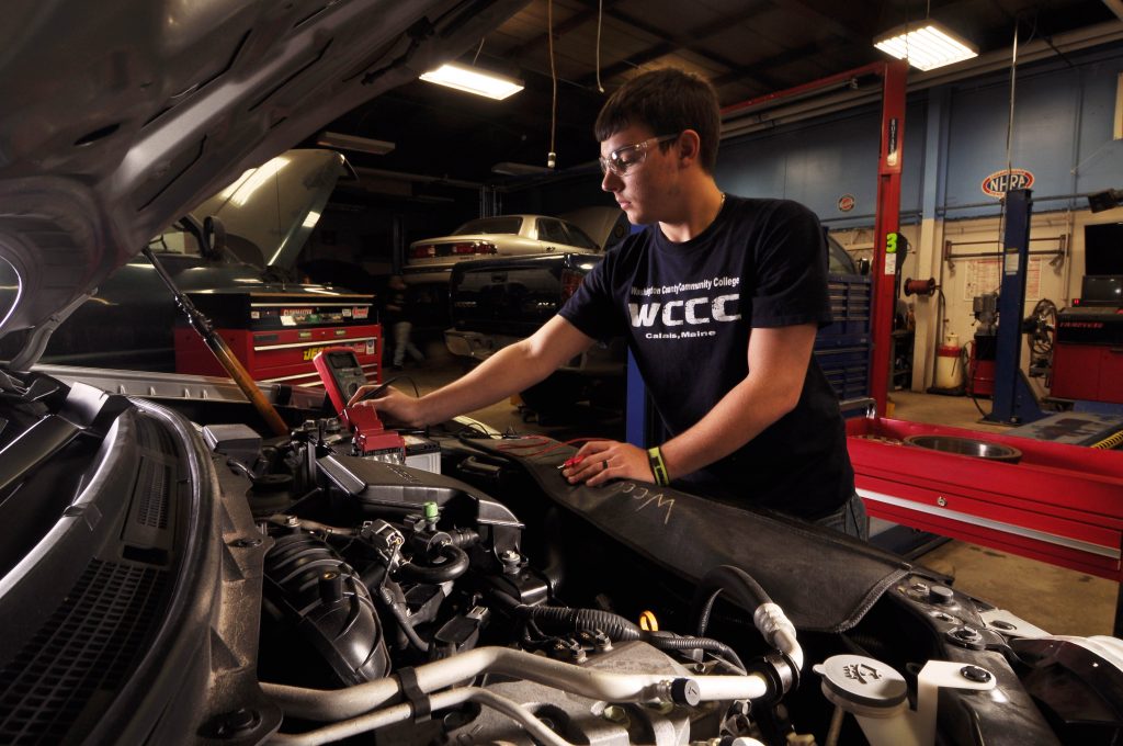Automotive Technology student checking an engine