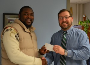 Student John Cowell accepting a scholarship from President Cassidy